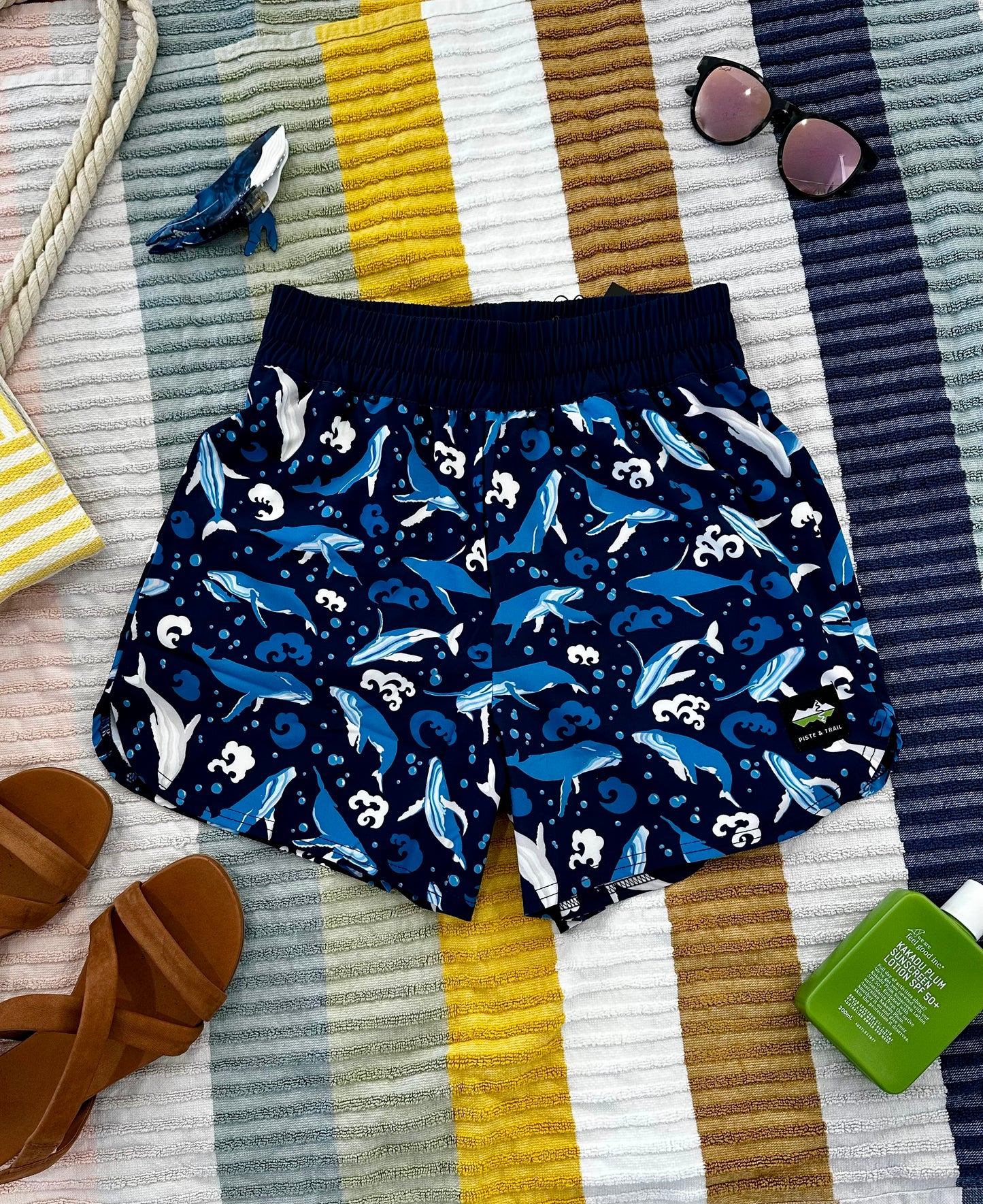 Navy shorts with humpback whale pattern on a striped fabric background
