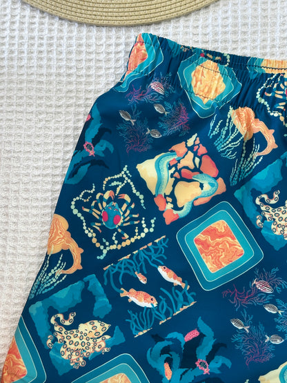Colorful ocean-themed fabric shorts with sea creatures on a textured surface