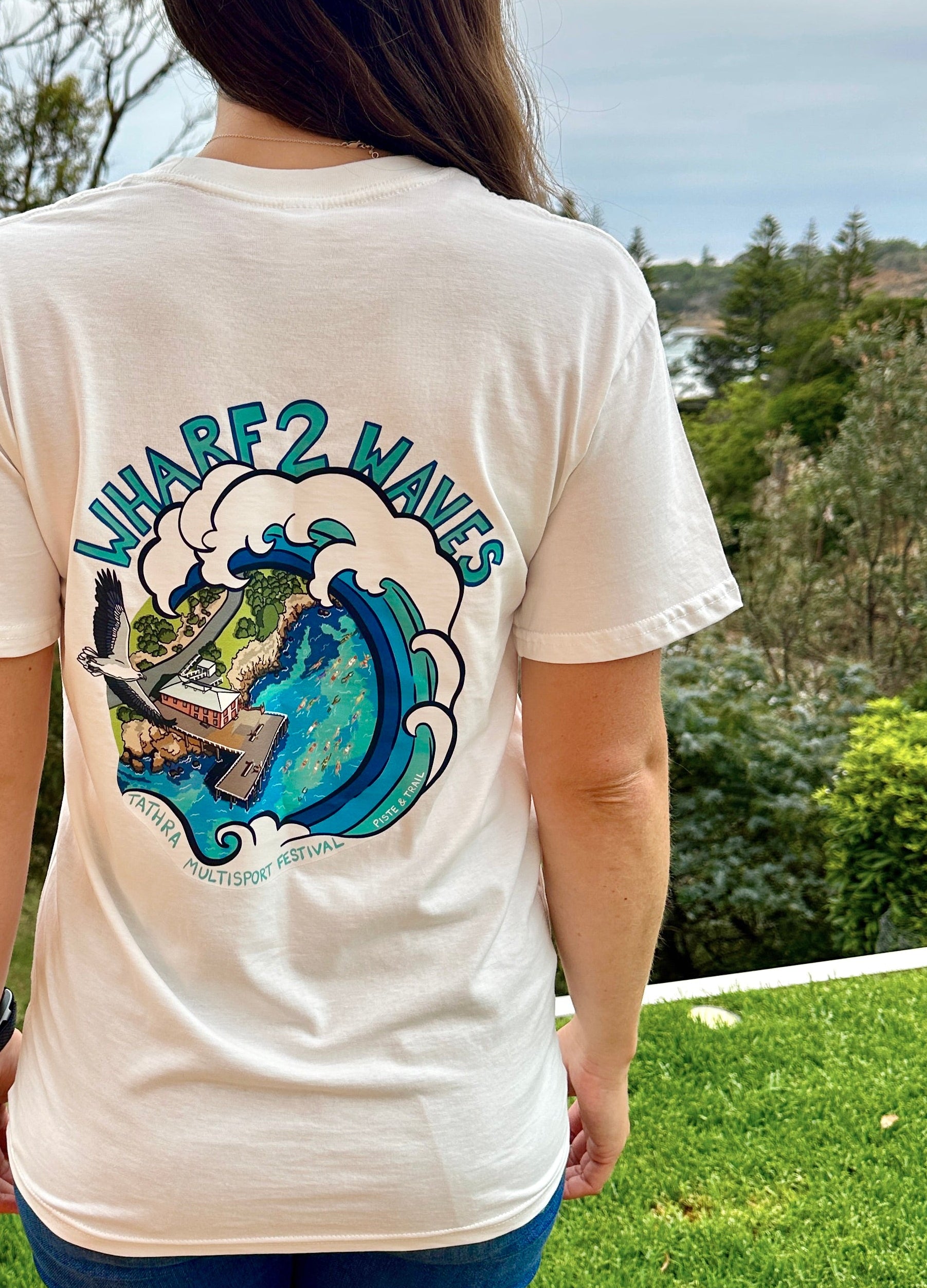 Person wearing a white t-shirt with a graphic design outdoors