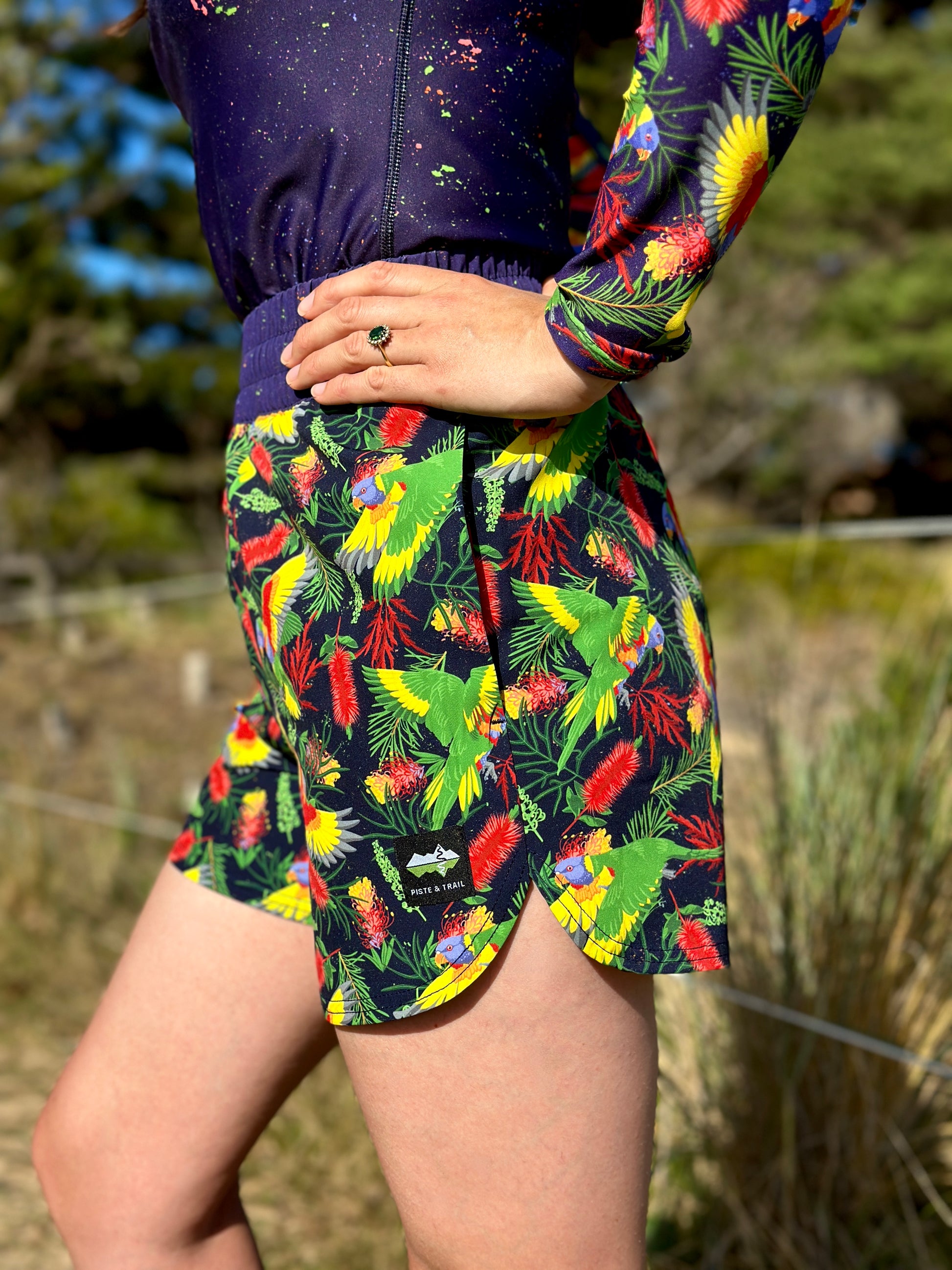 Person wearing a colorful parrot patterned skirt outdoors